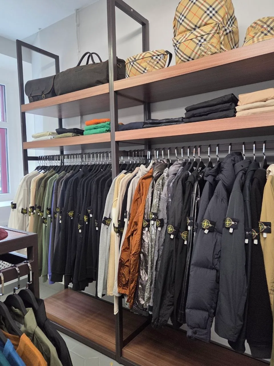 Стойка с куртками и одеждой Stone Island в магазине Rill Stuff